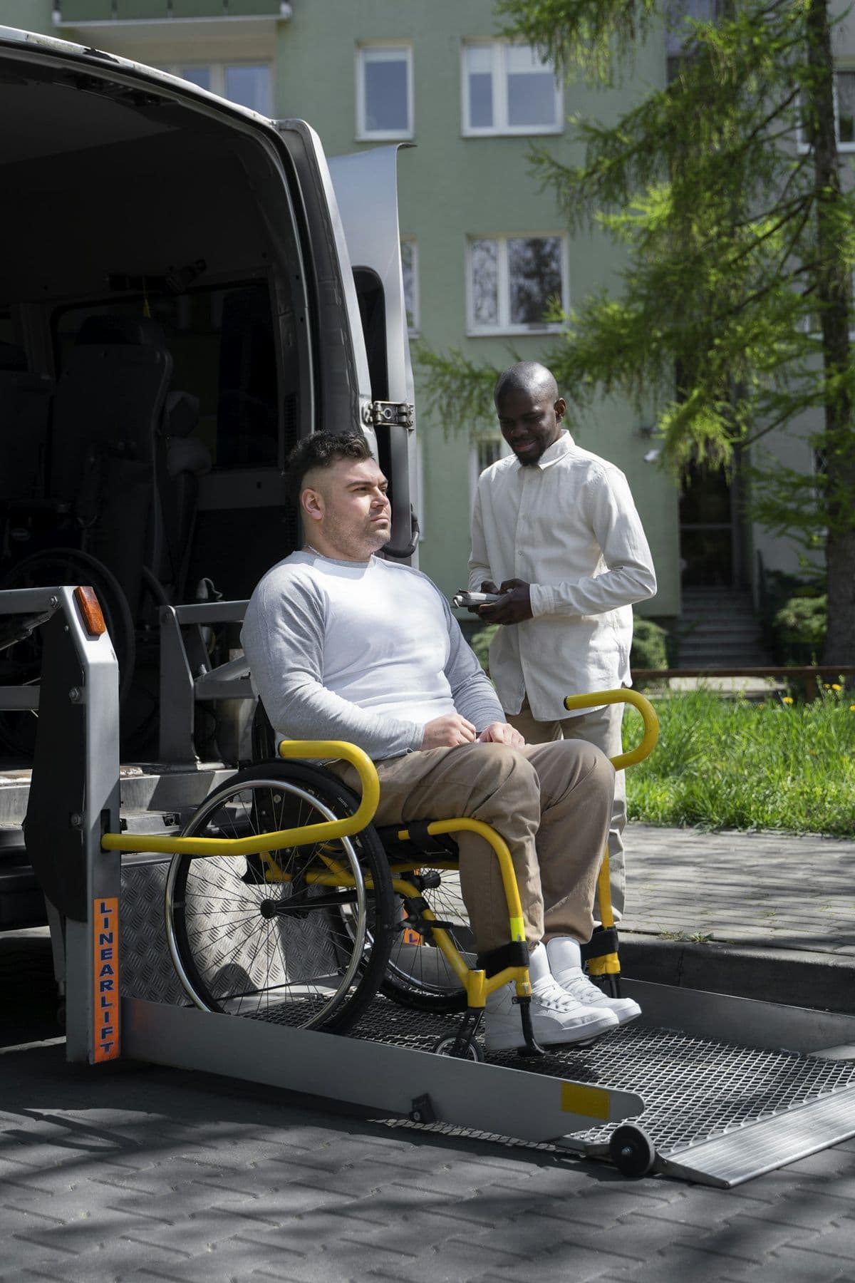Personne en fauteuil roulant accompagnée par un ambulancier